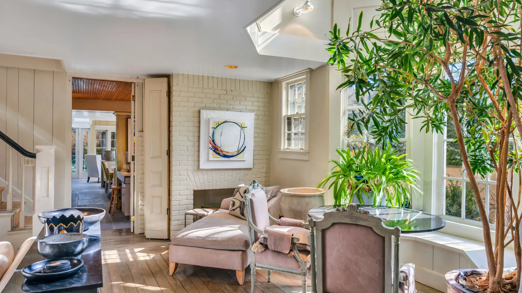 A bright living room with cushioned seating and large windows.