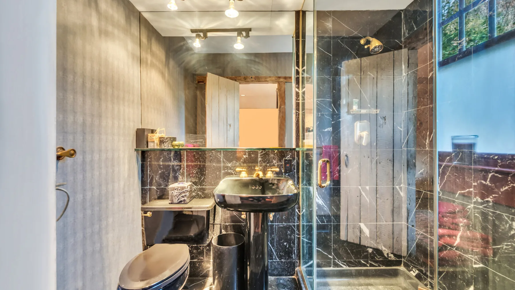 A bathroom with a sink, toilet, and glass shower.
