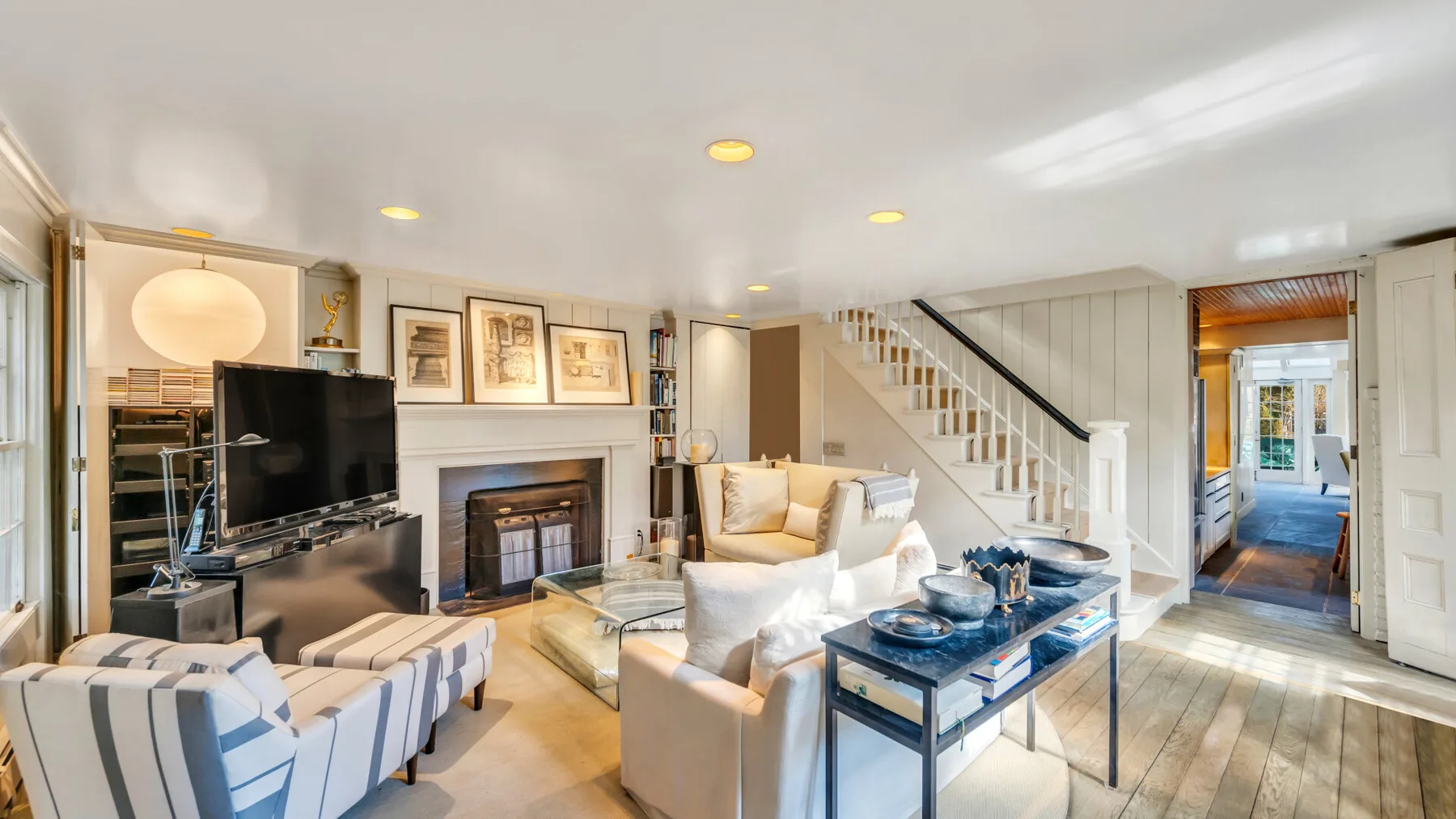A bright living room with seating arranged around a fireplace and coffee table.