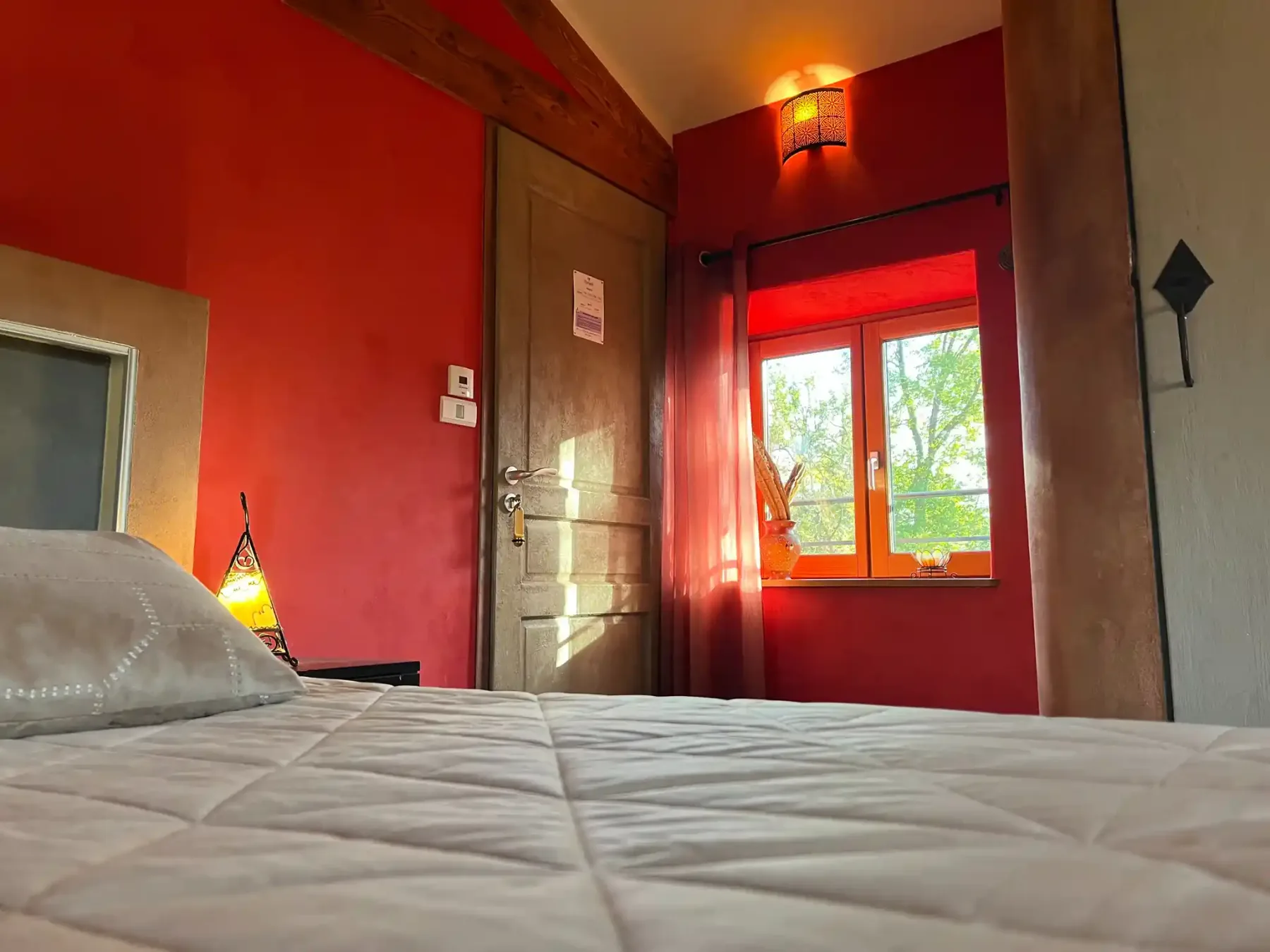 Chambre Marocaine avec lit et lumière naturelle.