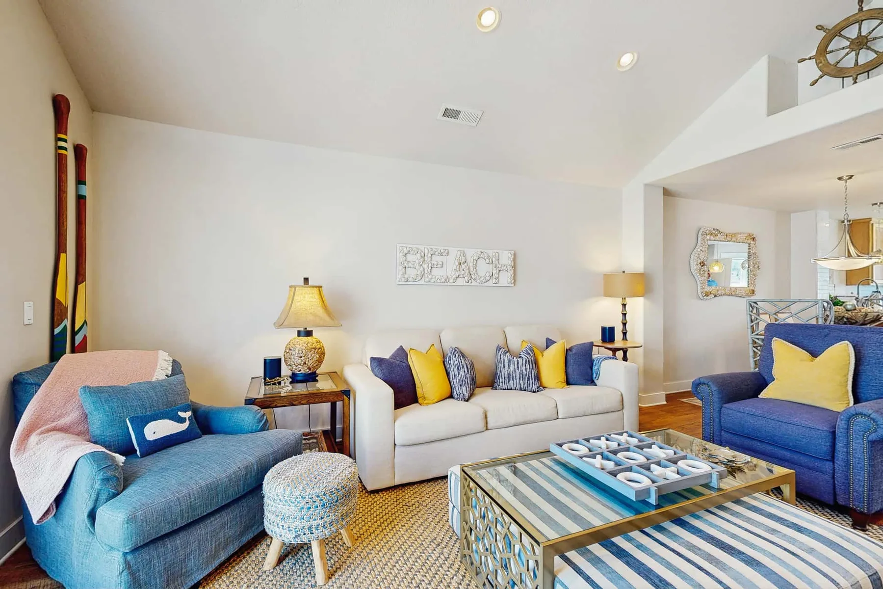 A bright living room with sofas, armchairs, and a patterned coffee table.
