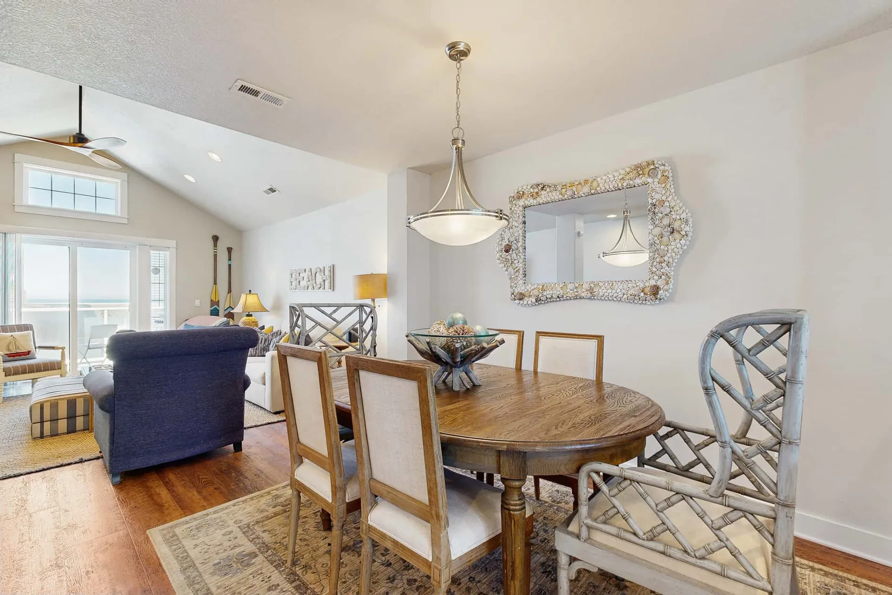 A dining area with a round wooden table and upholstered seating.