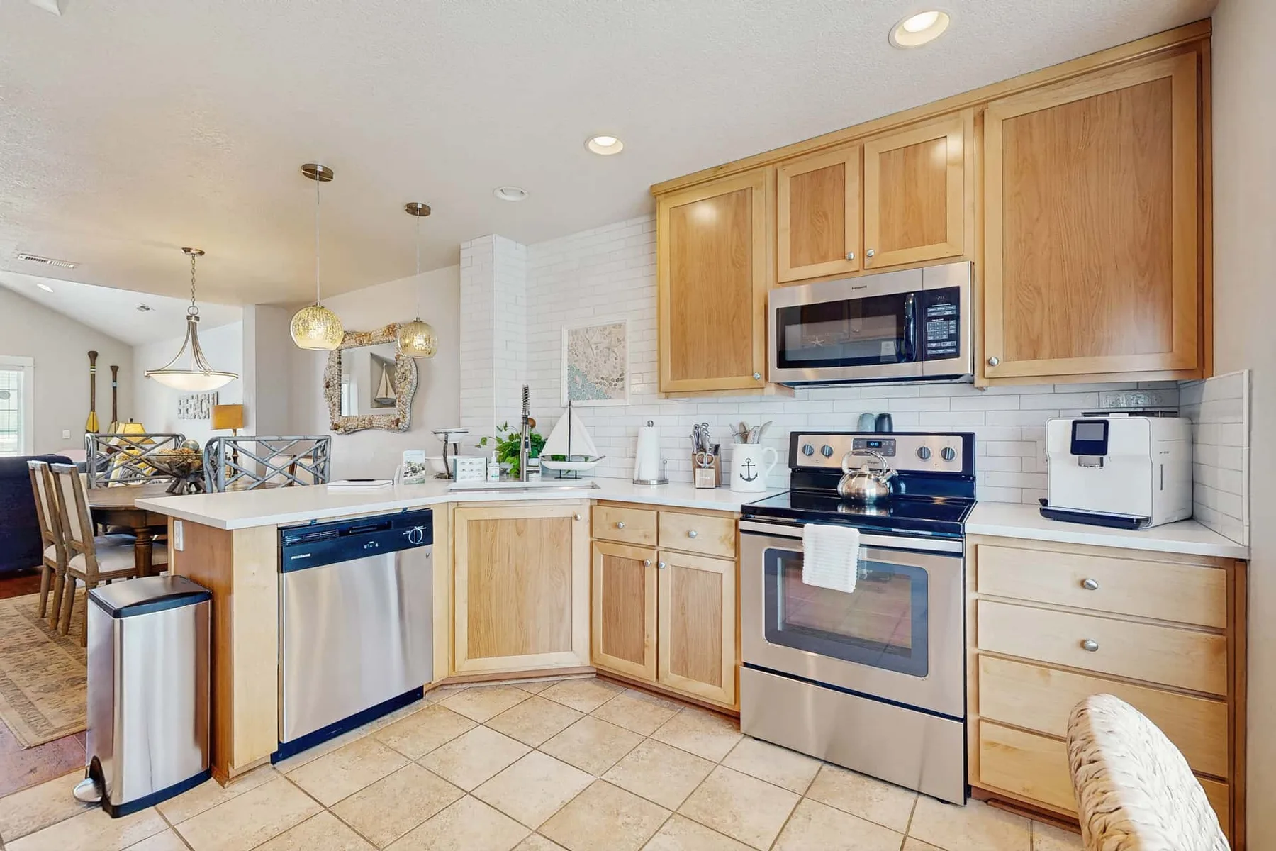 A bright kitchen with wooden cabinets, a stove, and a central island.