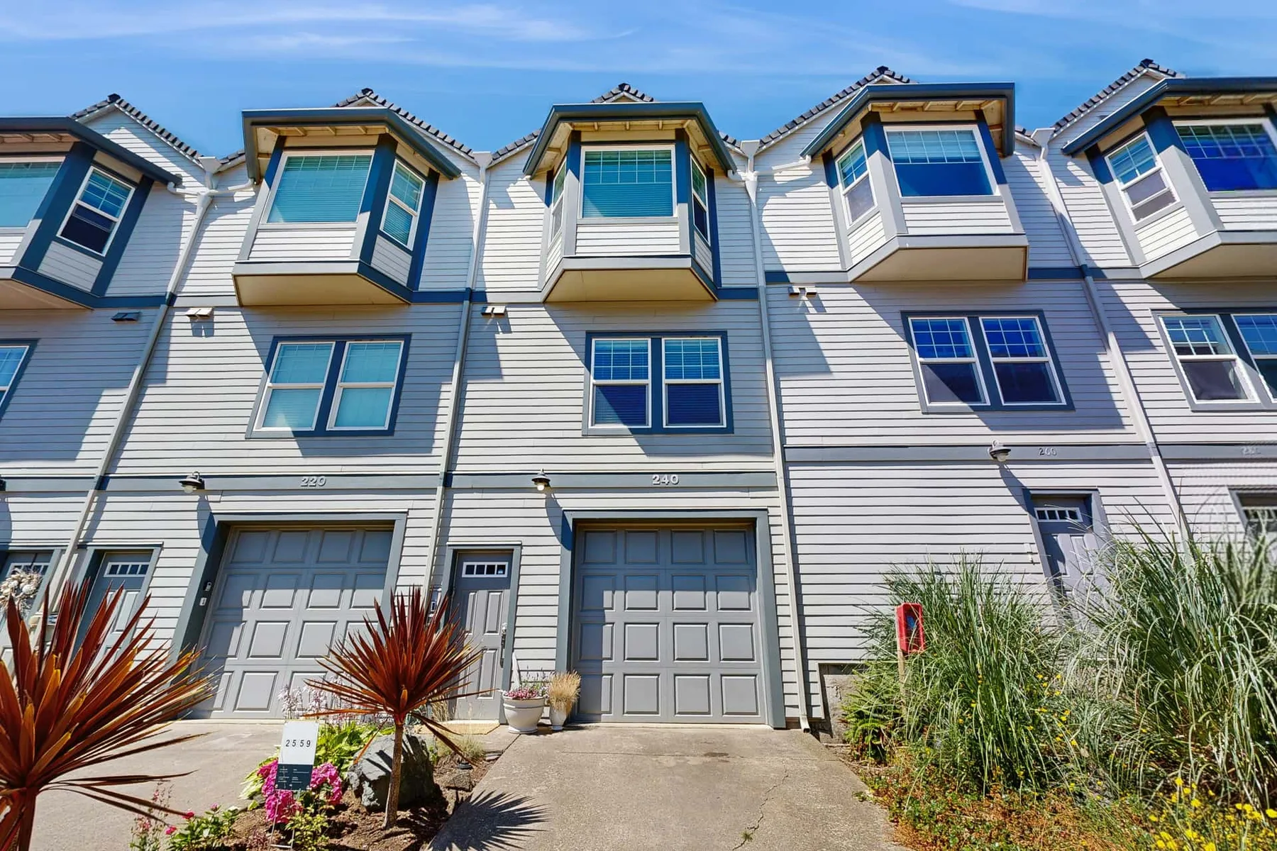 A row of attached houses with garage doors and projecting upper windows.