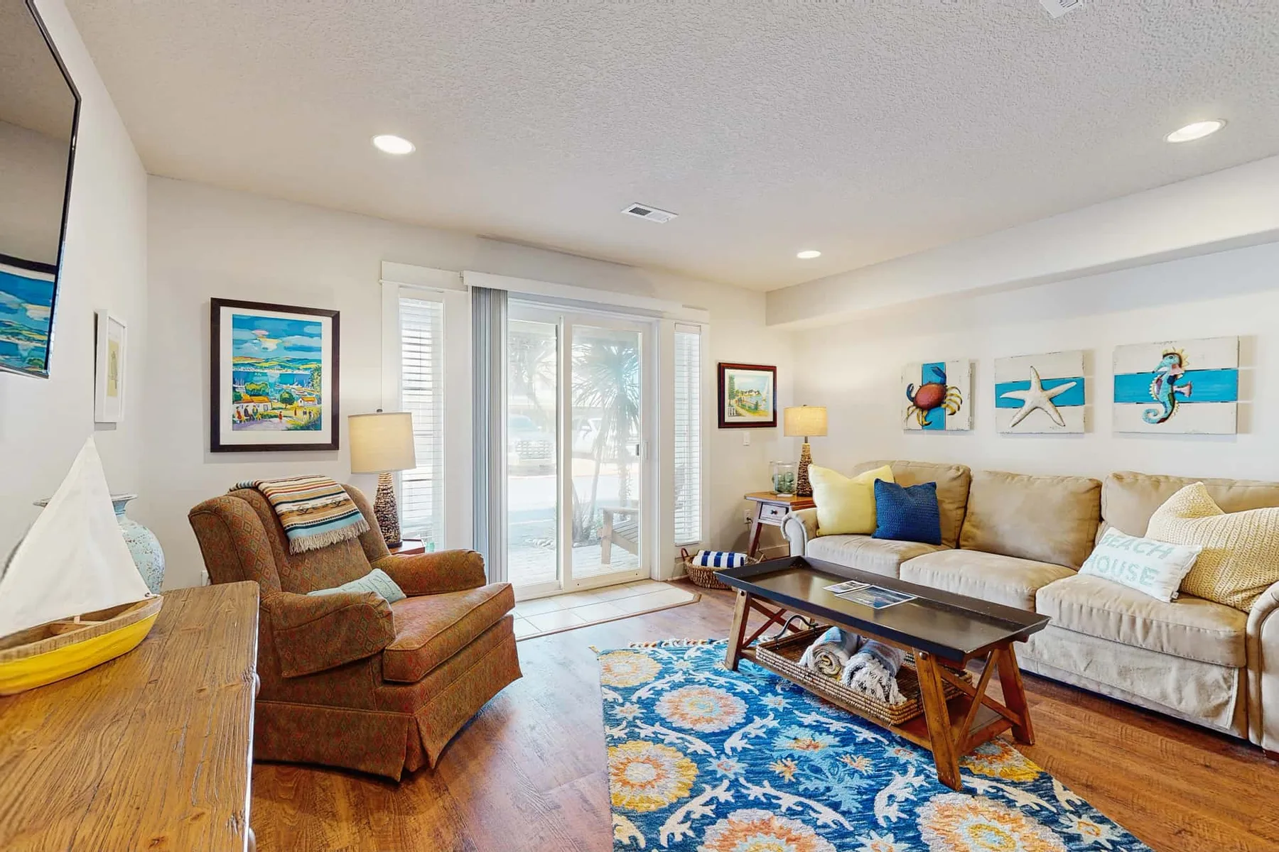 Living room with seating around a coffee table and a colorful rug.