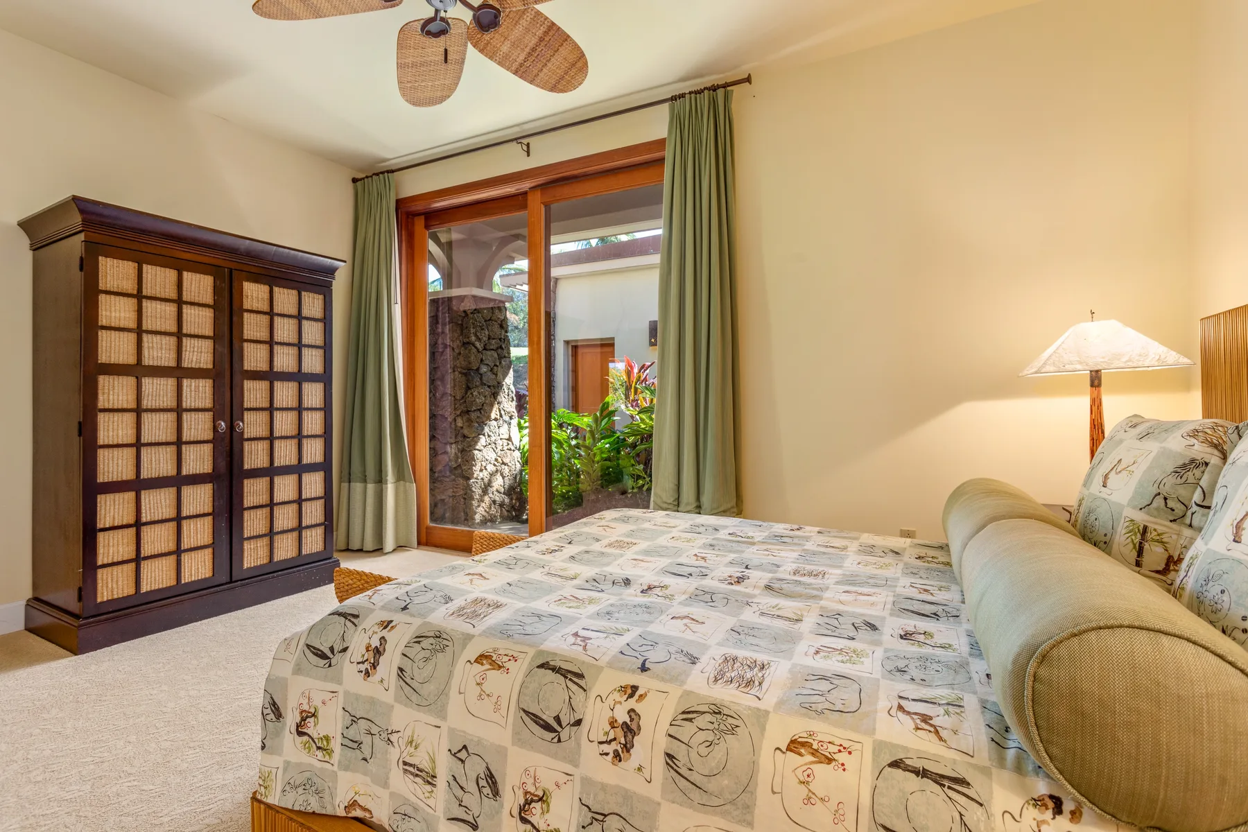 A bedroom with a bed, a wardrobe, and a glass door opening to a garden.