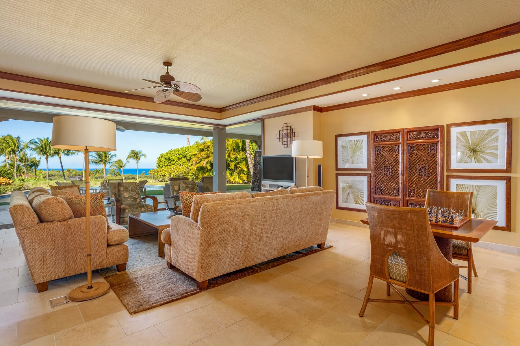 A bright living and dining area opens onto a patio with a view of the ocean.