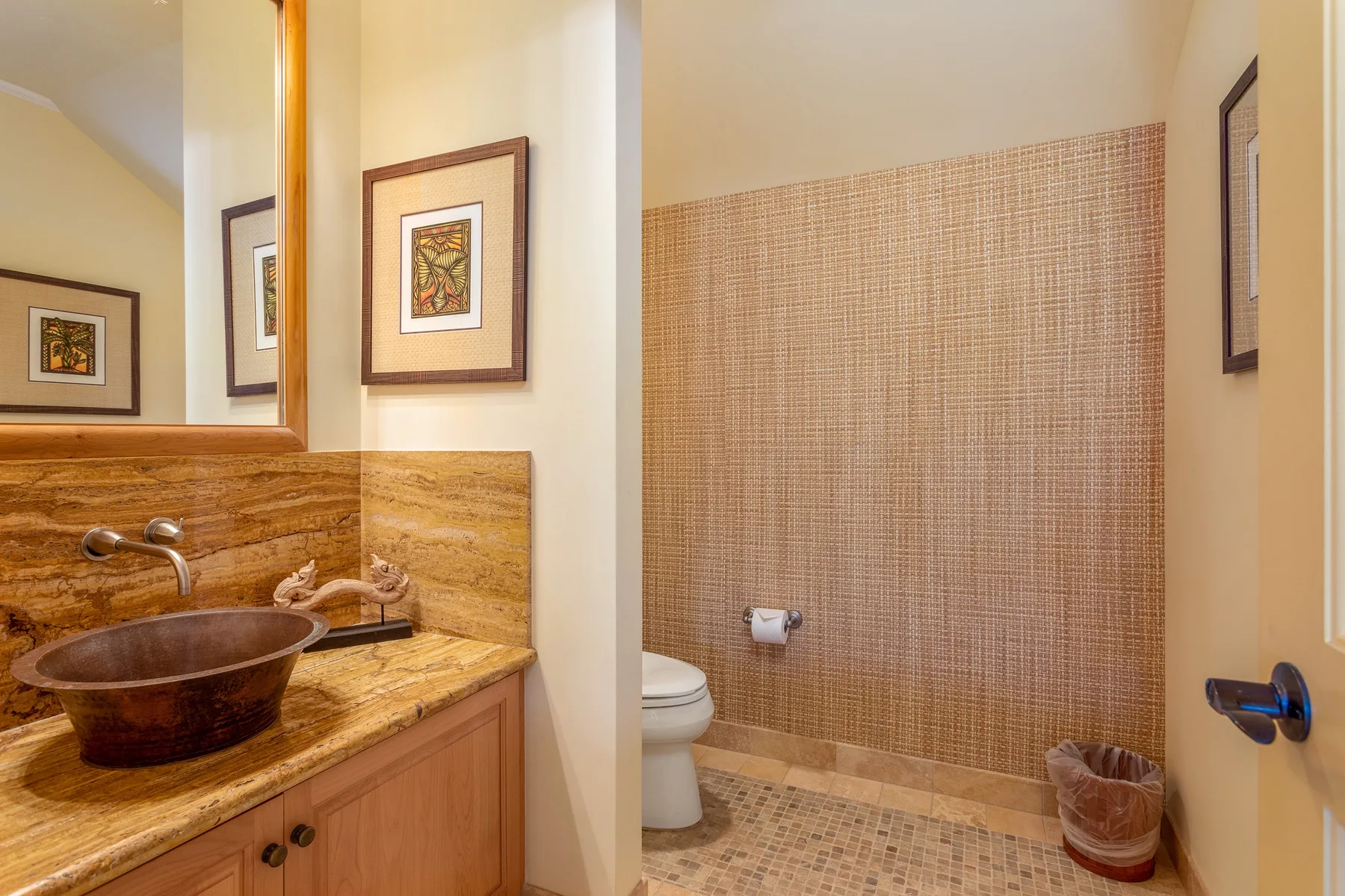 A bathroom with a vessel sink, toilet, and tiled shower area.