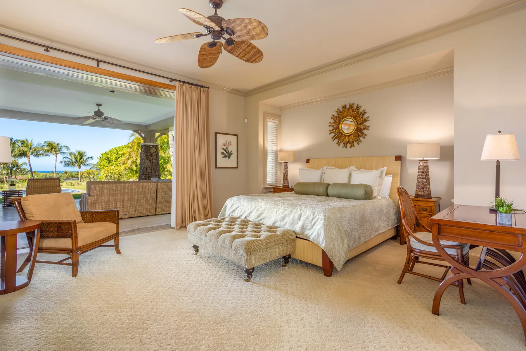 A bedroom with a large bed and an open view onto a furnished patio.