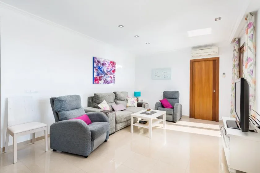 A bright living room with seating arranged around a white coffee table.
