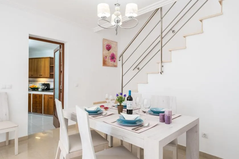 A dining area with a set table beside a staircase.