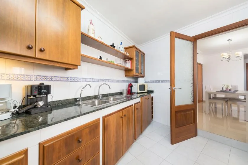 A kitchen with wooden cabinets and a countertop beside an open doorway.