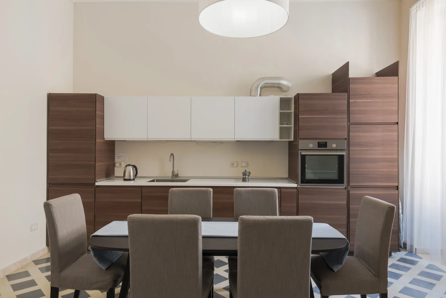 Comedor con mesa y sillas junto a una cocina moderna.