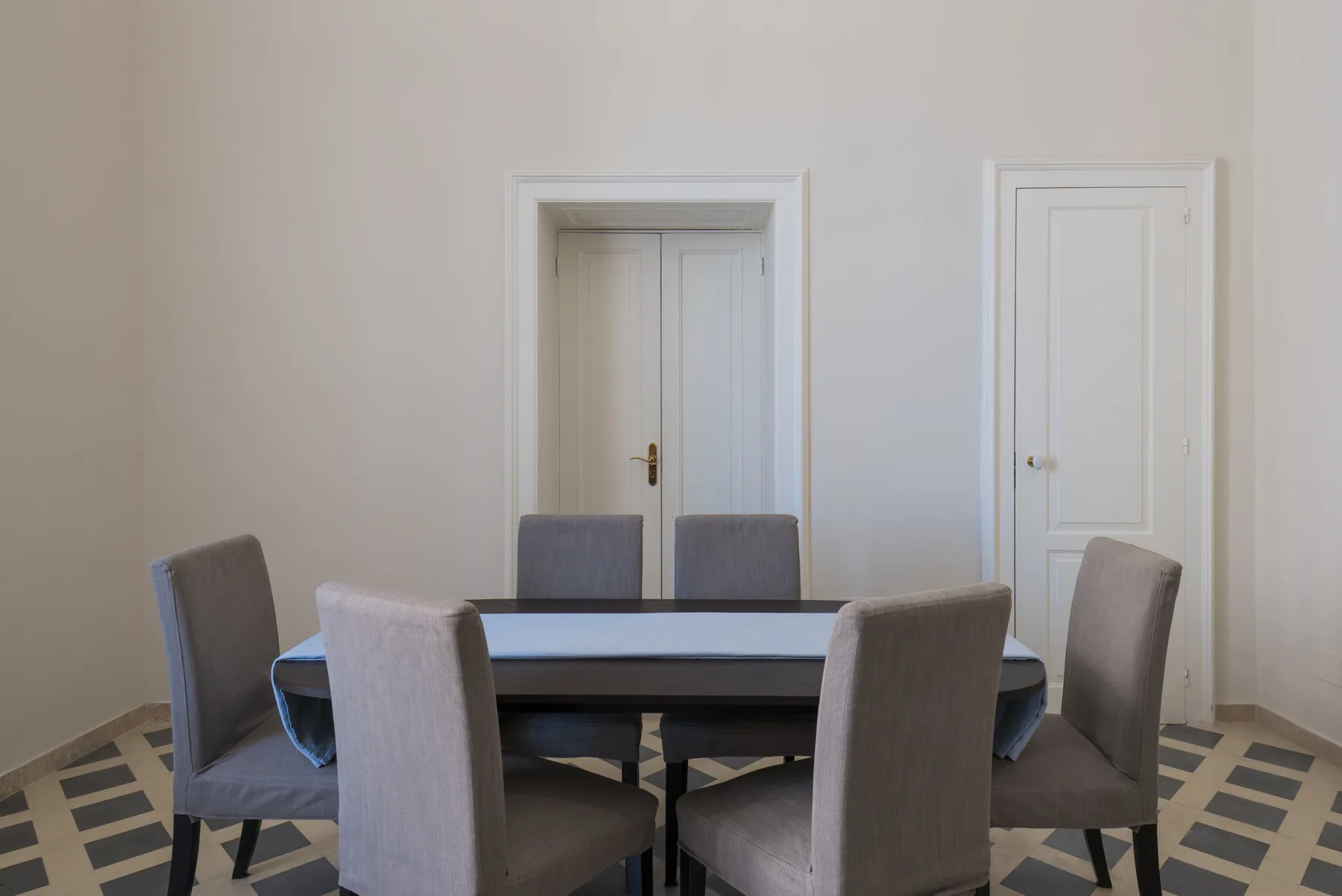 Un comedor con una mesa rectangular y asientos tapizados.