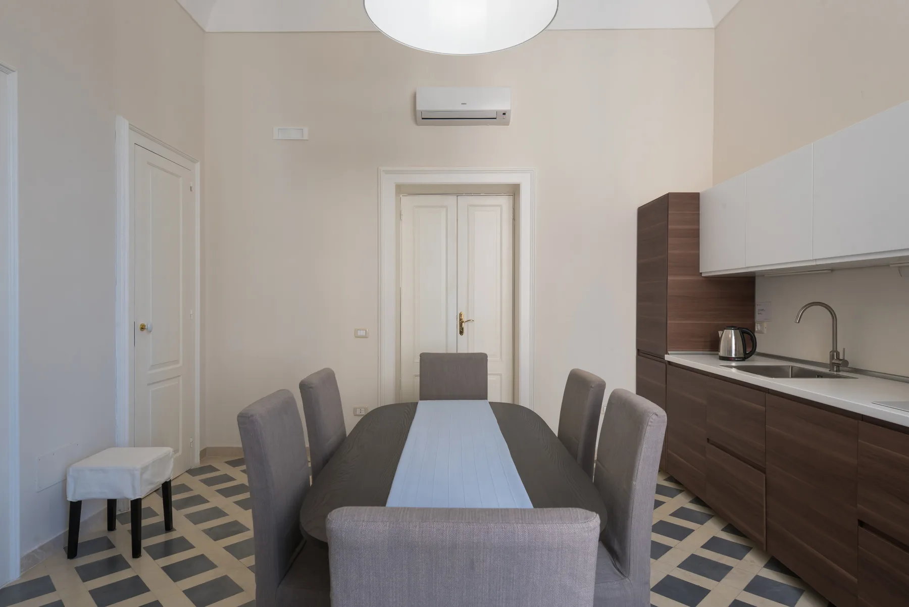 Comedor con una mesa larga y una pequeña cocina junto a la pared.