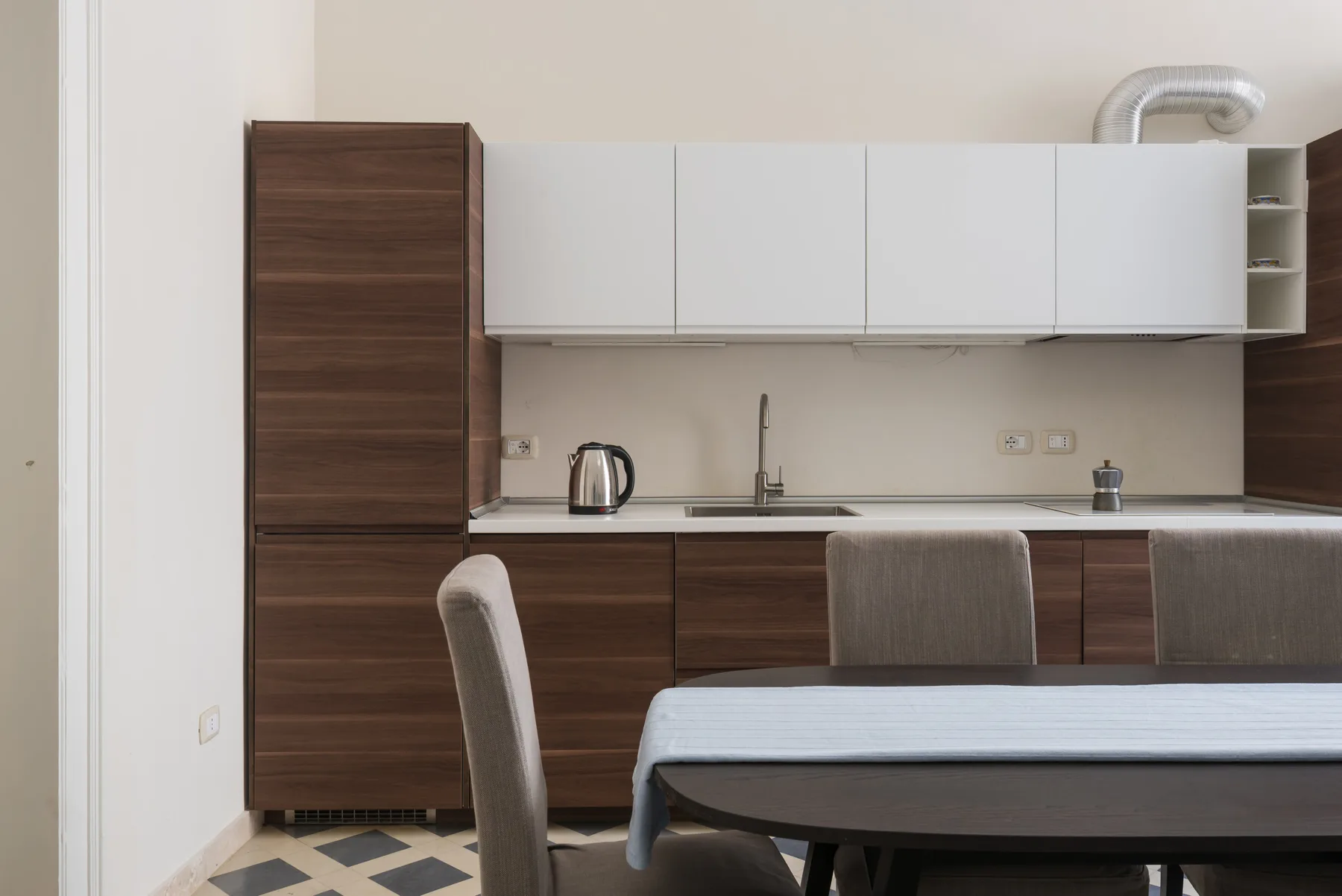 Un comedor con una mesa y sillas frente a una encimera de cocina.