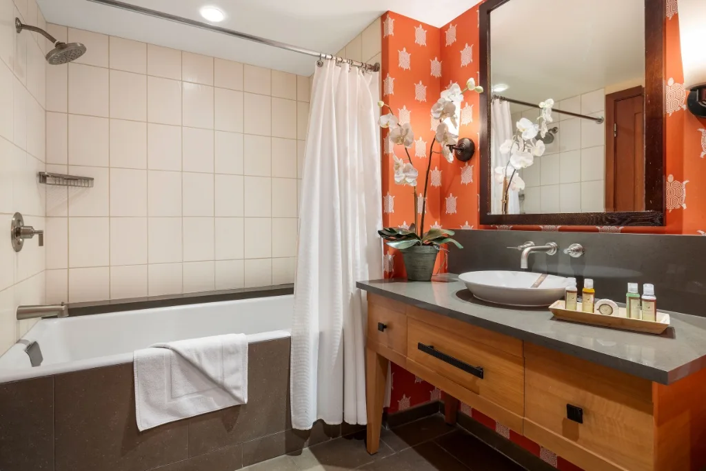 Un baño con bañera, cortina de ducha y lavabo.