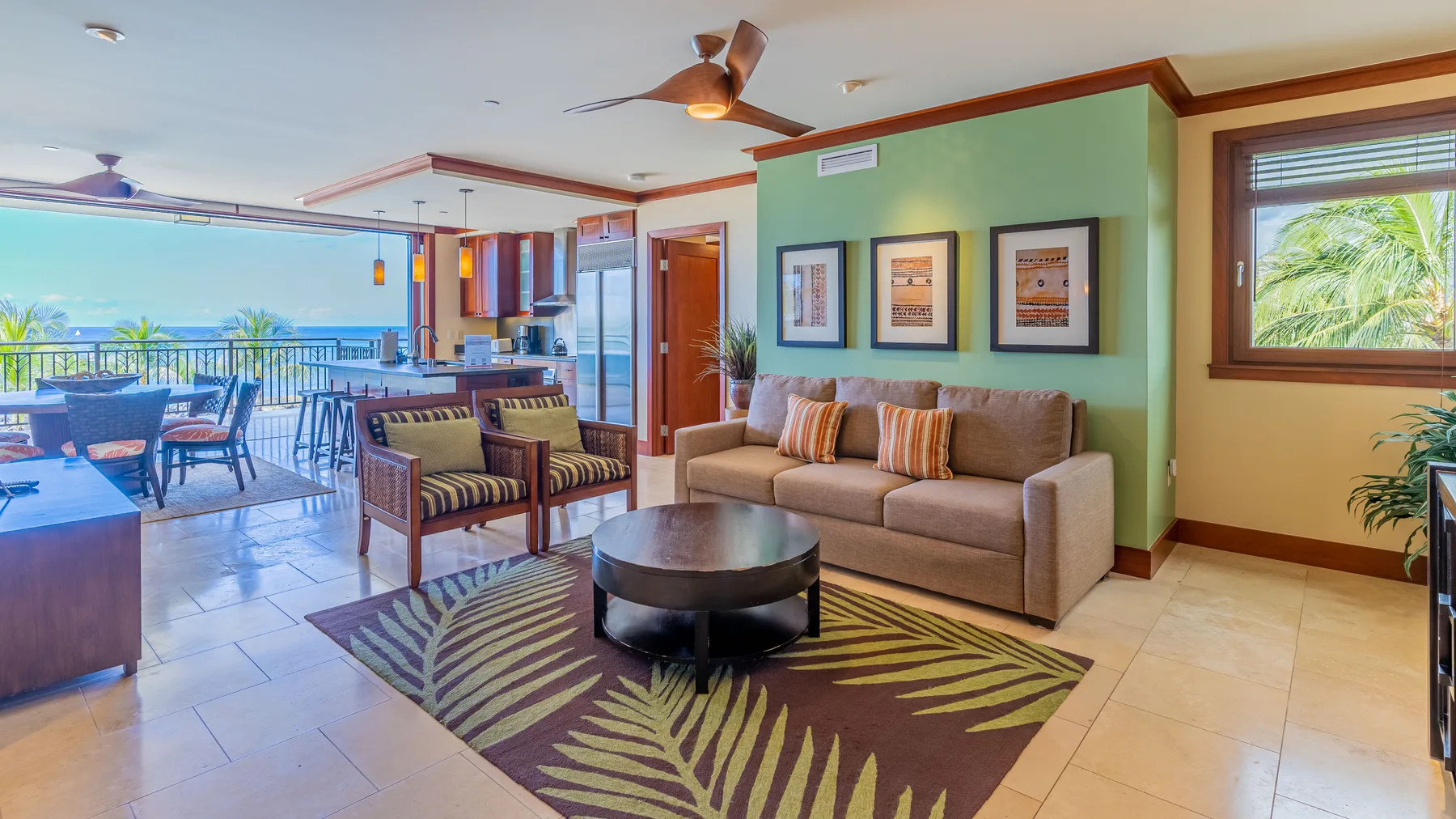 Una sala de estar con sofá, alfombra estampada y comedor junto a las ventanas.