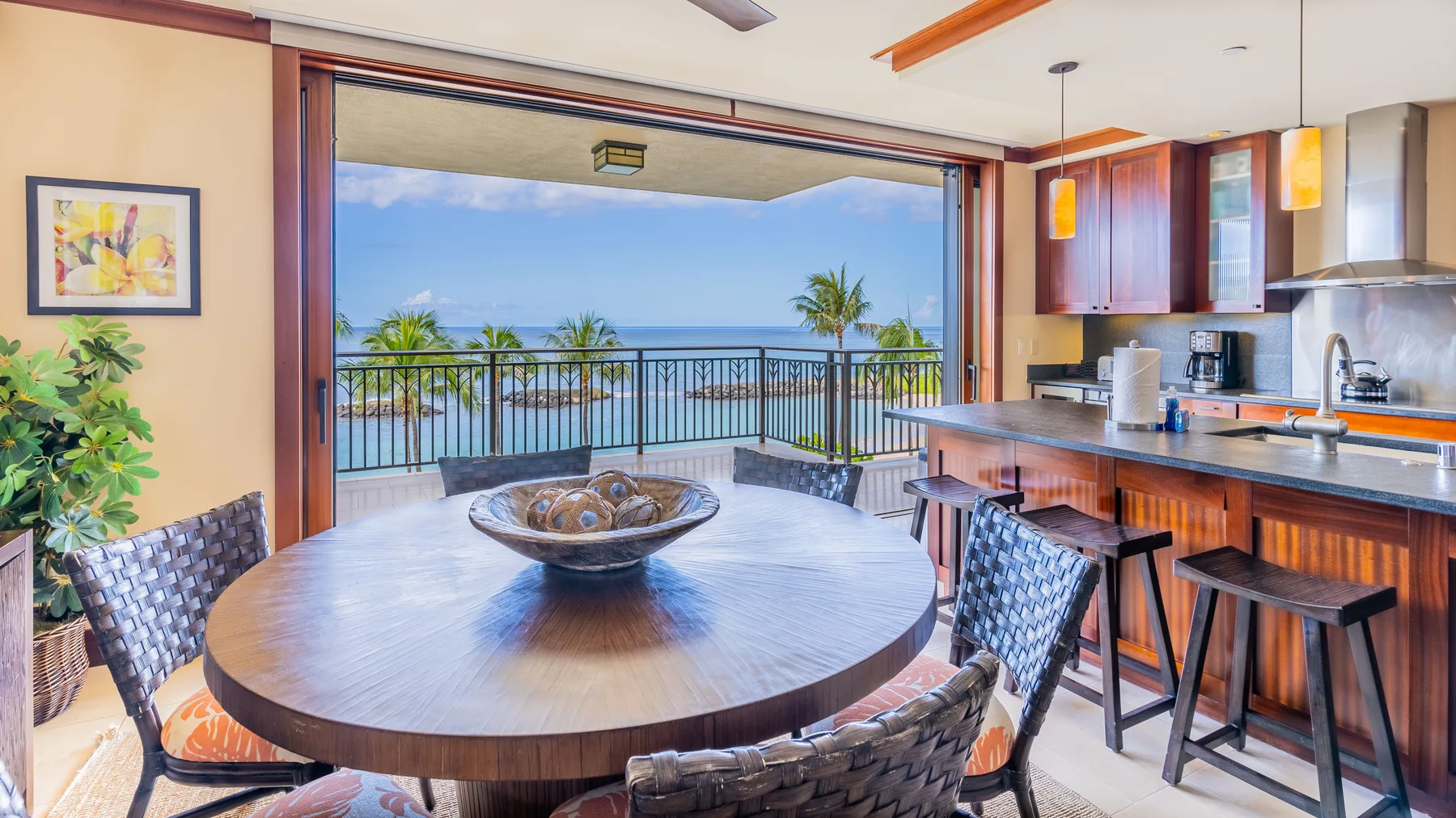 Una cocina y comedor de concepto abierto dan a un balcón con vistas al mar.