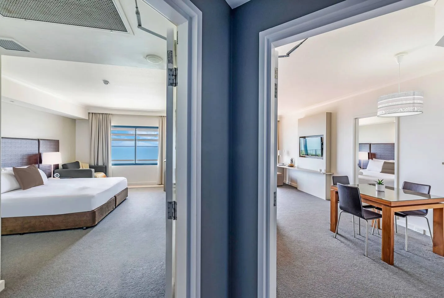 Two adjoining bedroom and living areas are visible through open doorways.