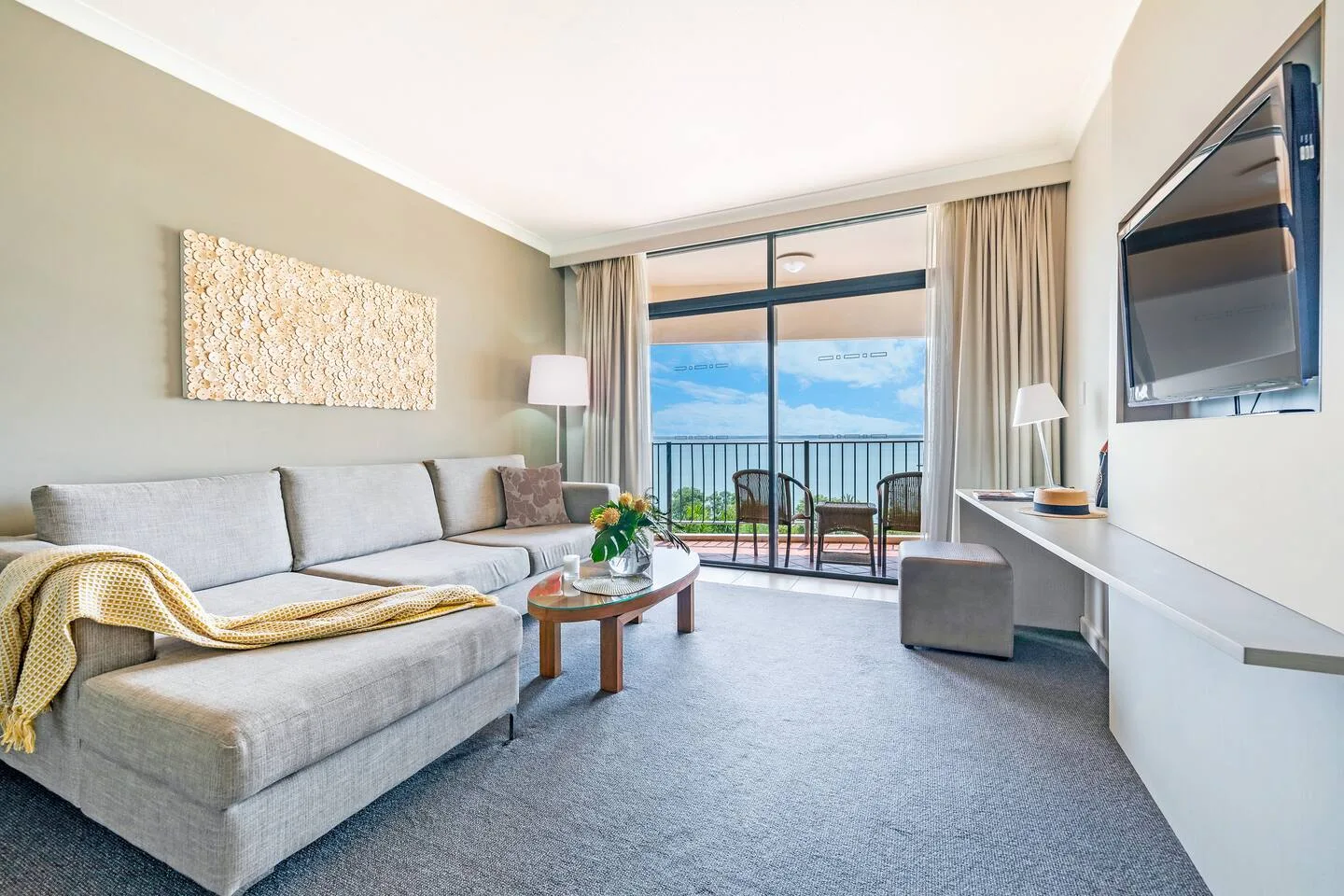 A living room with seating and a glass door opening onto a balcony.