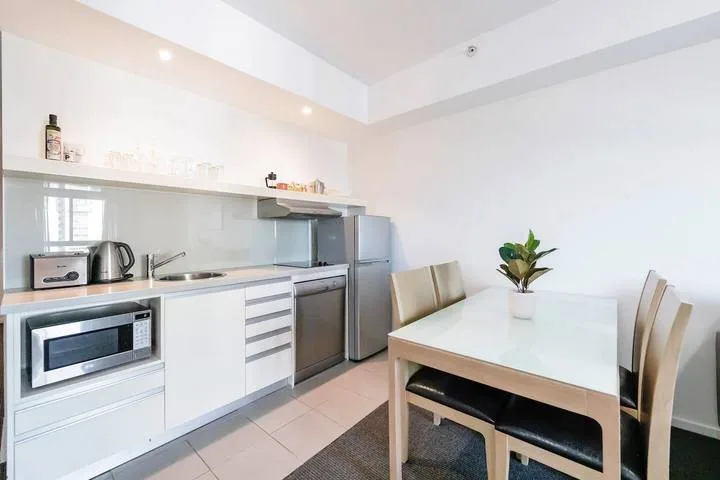 A bright kitchen and dining area with a table and built-in appliances.