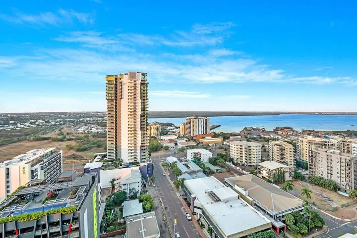 Aerial view of a coastal city with high-rise buildings and a road.