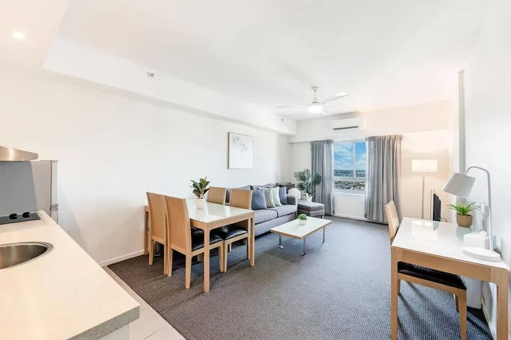An open-plan living and dining area with a compact kitchen and balcony doors.