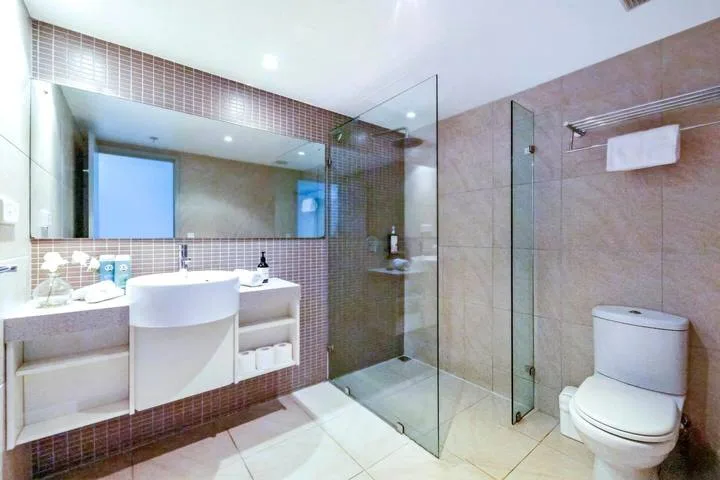 A tiled bathroom with a sink, toilet, and glass shower.