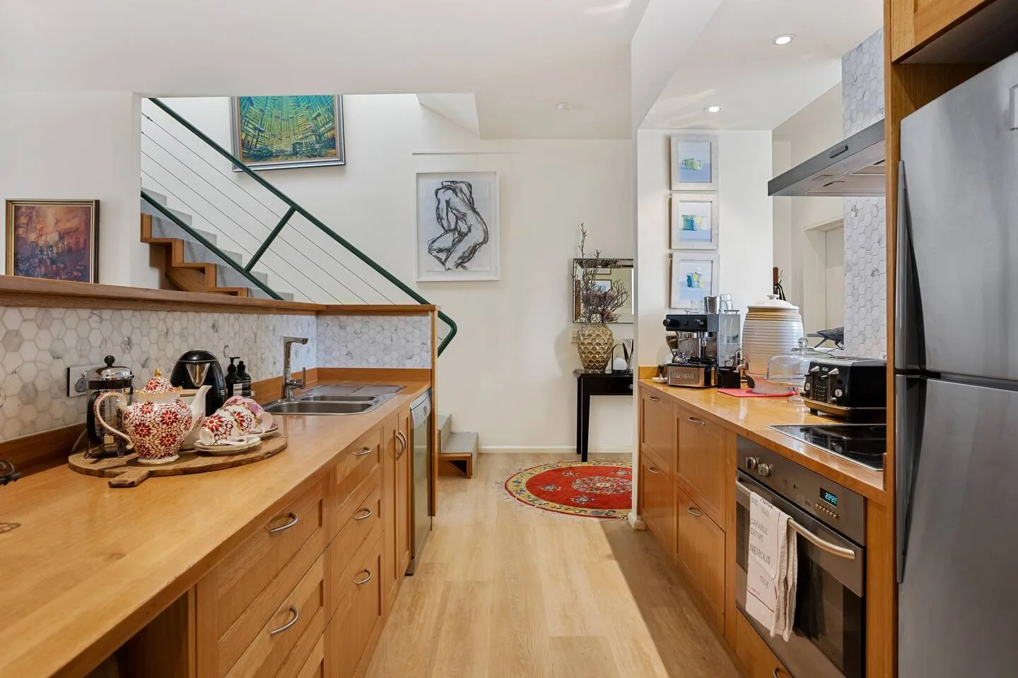 Una cocina luminosa con encimeras de madera y una escalera junto a la pared.