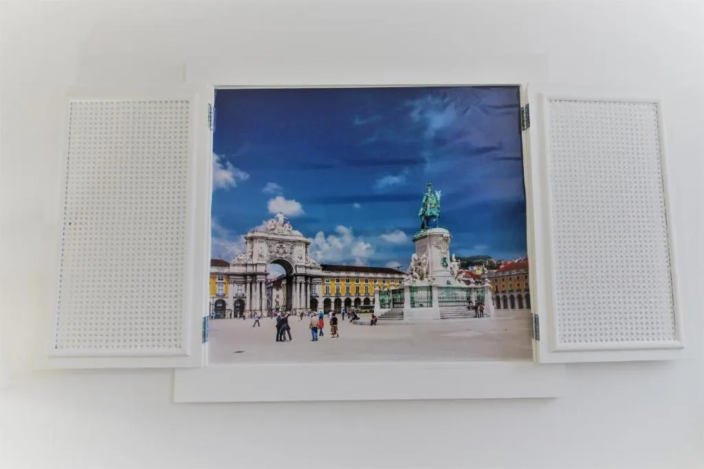 A framed cityscape print showing a plaza, an arch, and a statue.