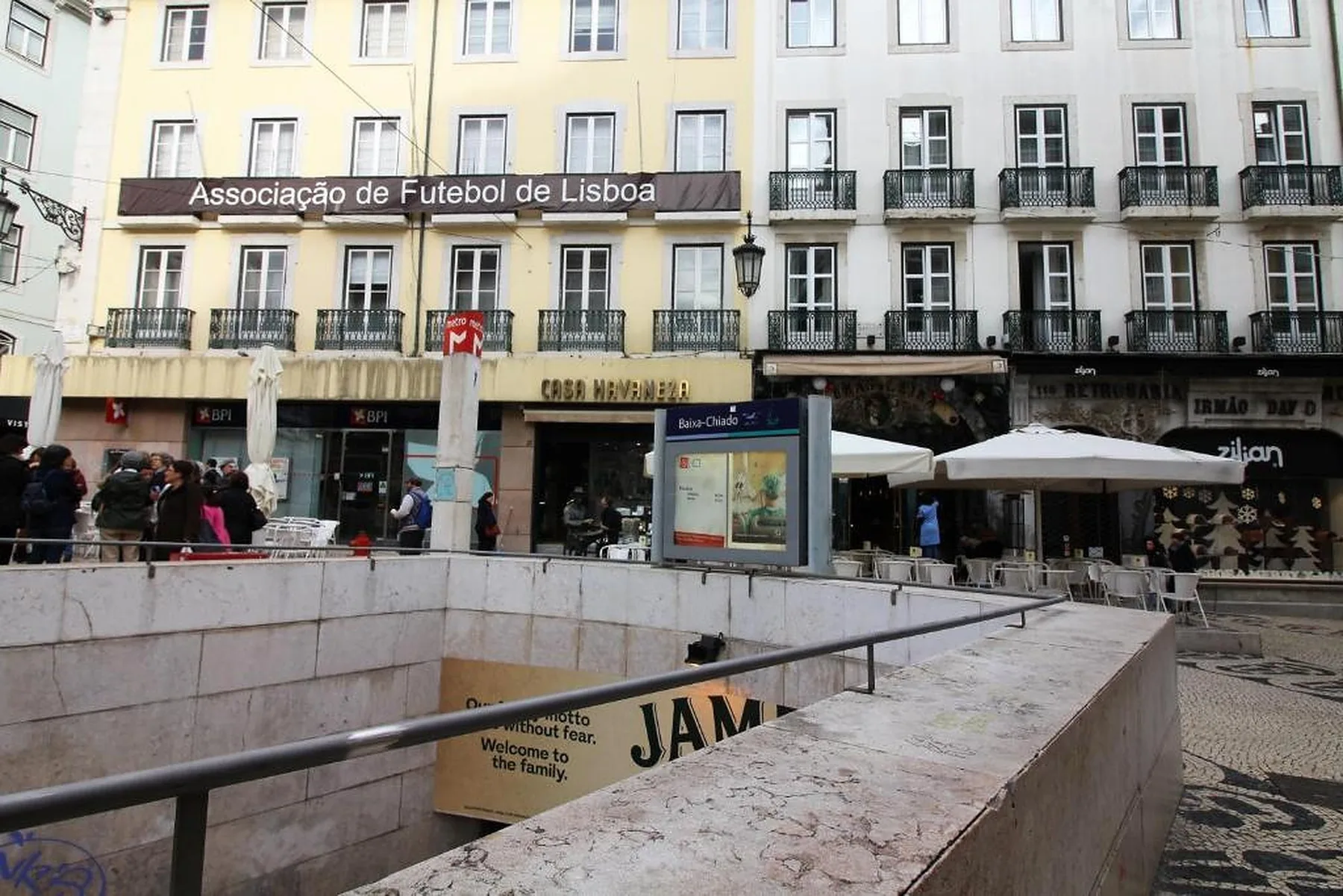 A Lisbon street scene with historic facades, shops, and a pedestrian plaza.