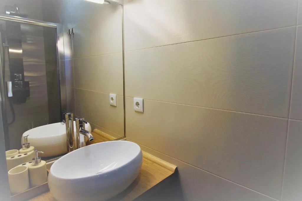 A bathroom vanity with a white vessel sink and wall mirror.