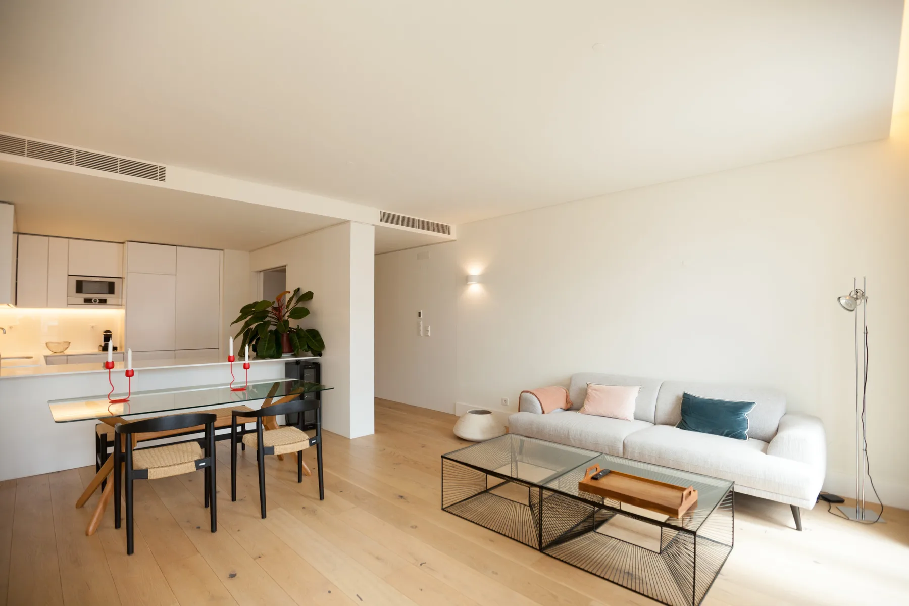 Una sala de estar y comedor de planta abierta con cocina, sofá y mesa de centro.