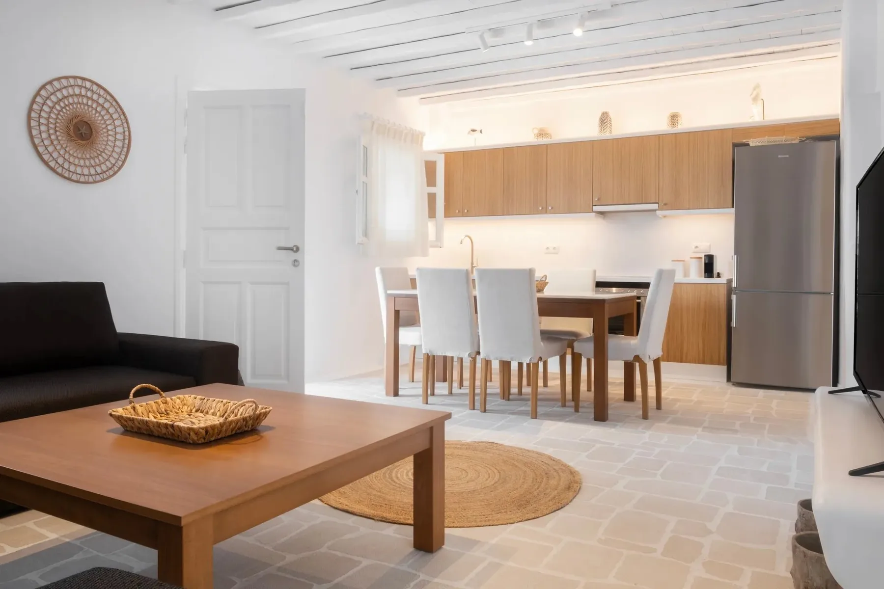 Sala y comedor de planta abierta con cocina y muebles de madera.