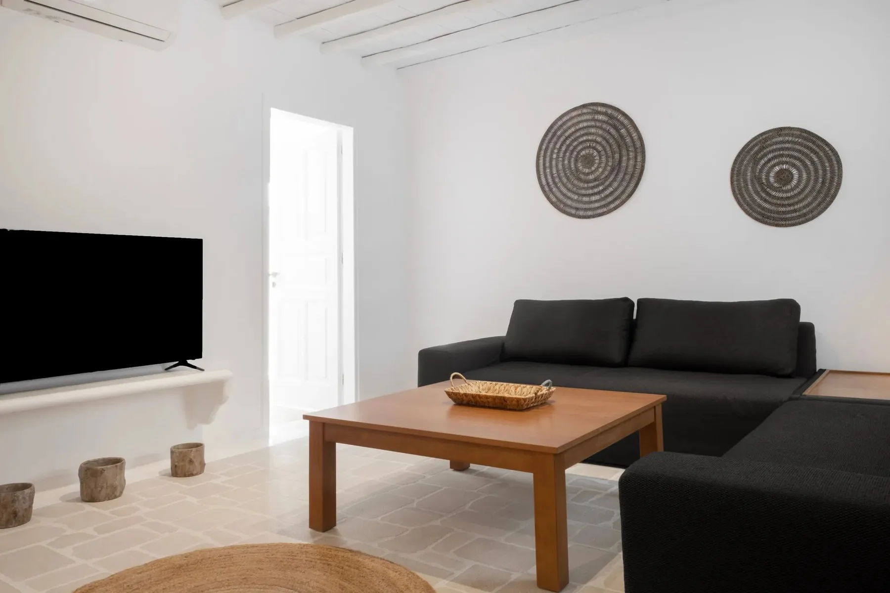 Una sala luminosa con asientos oscuros y una mesa de centro de madera.