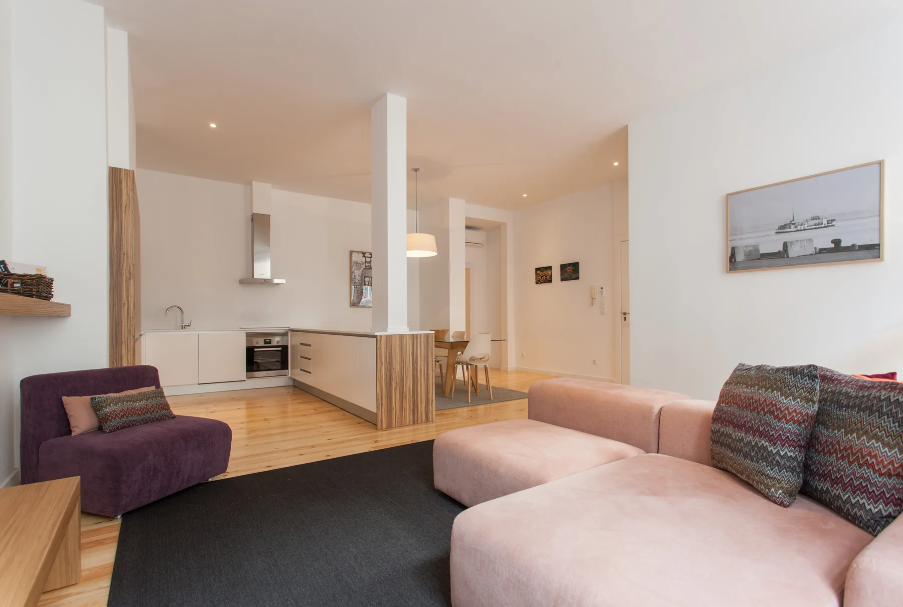Una sala de estar y cocina diáfanas, con una zona de descanso y una mesa de comedor.