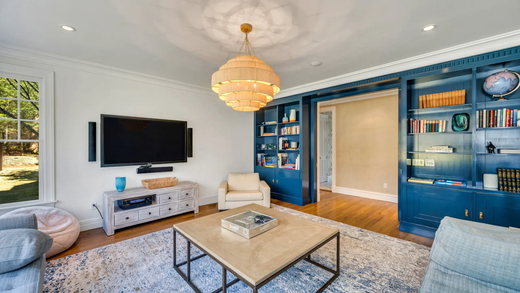 Una sala de estar con estanterías empotradas azules y una mesa de centro.