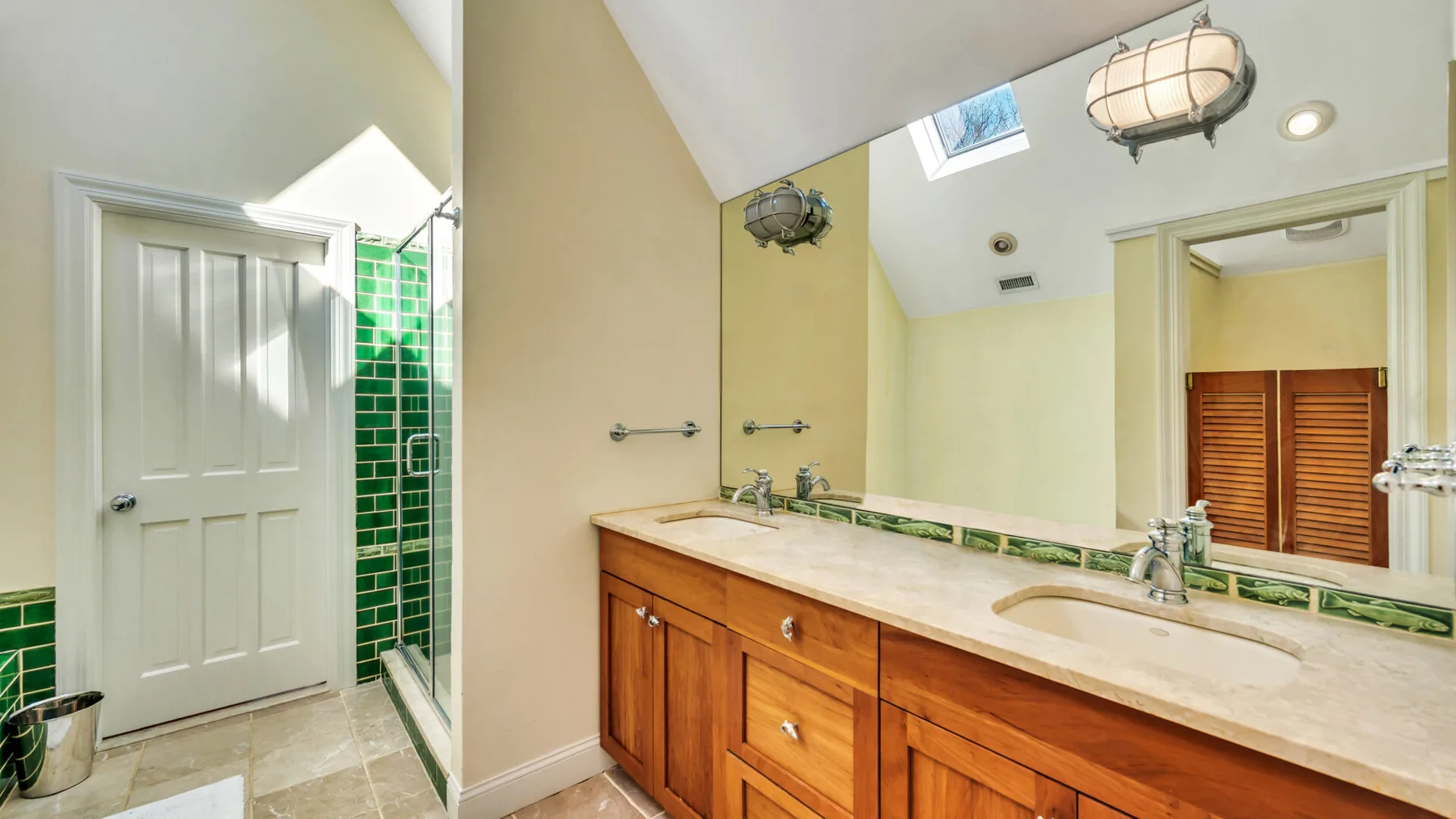 Un tocador de baño con una encimera larga y un espejo grande.