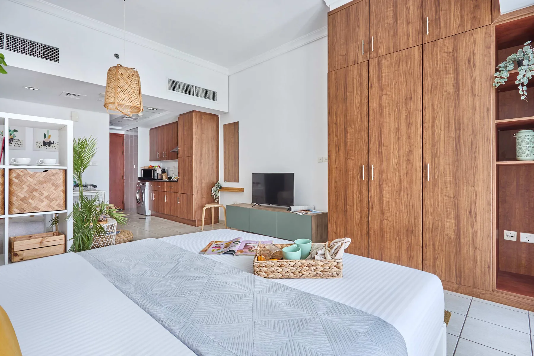 Un dormitorio con una cama, armarios de madera y un televisor.