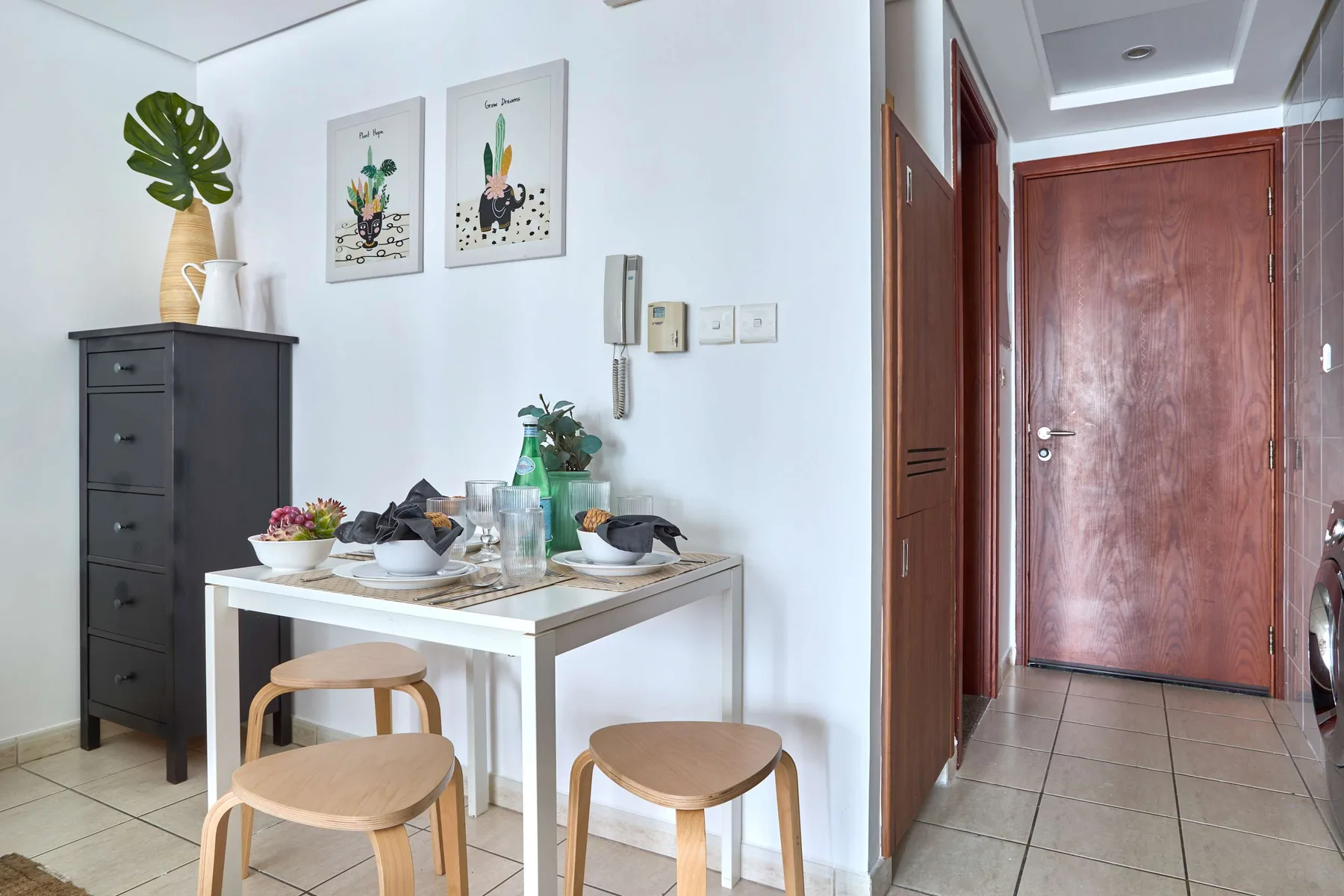 Un comedor con una mesa con platos y láminas enmarcadas en la pared.