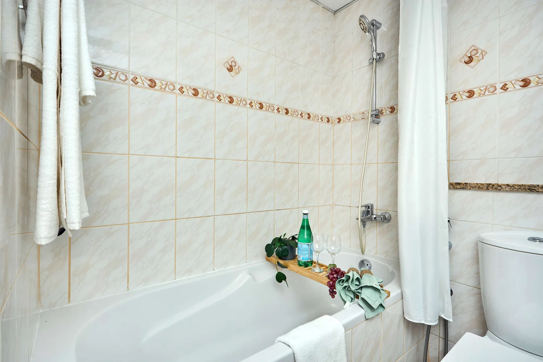 Un baño con azulejos, bañera y cortina de ducha.