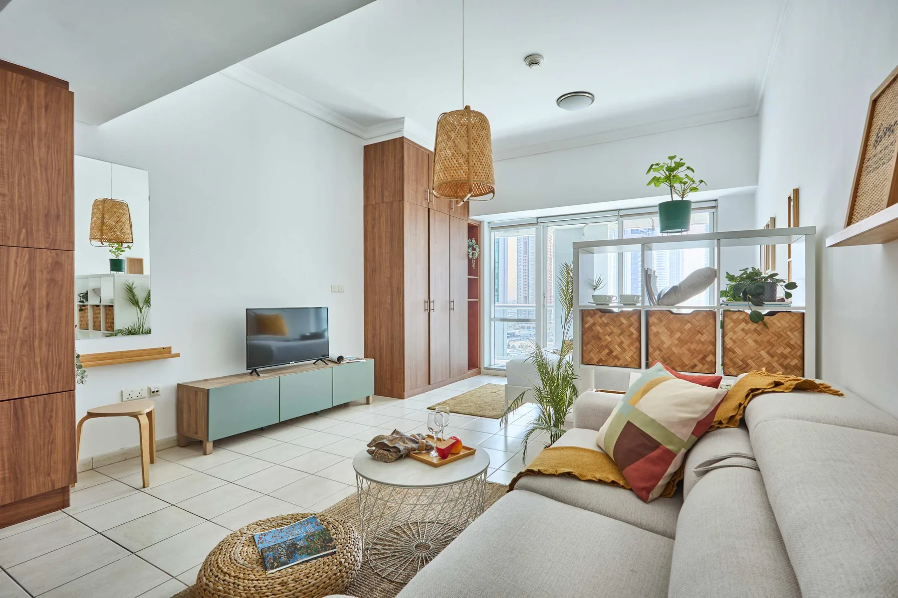 Una sala luminosa con una zona de asientos y grandes ventanas.
