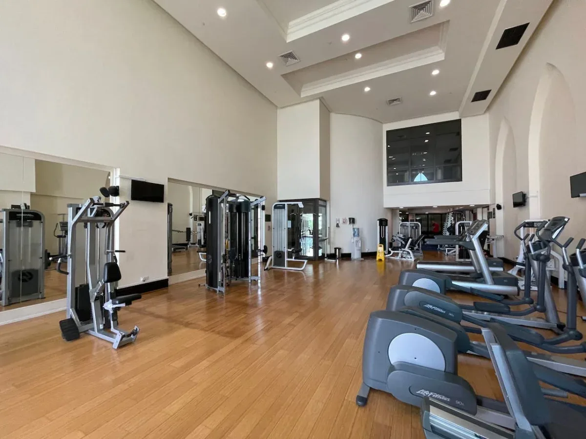 A gym with exercise machines arranged across a spacious room.