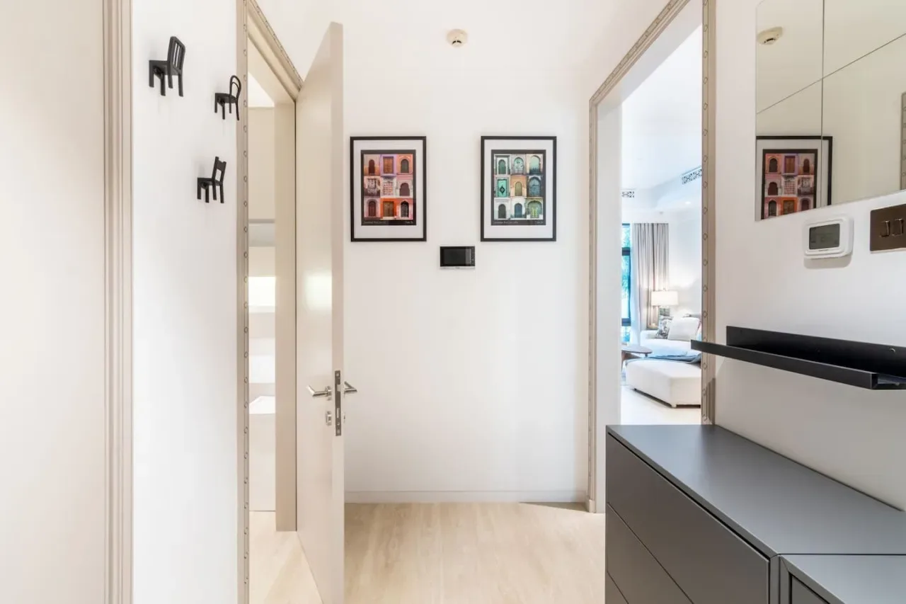 A bright hallway with framed artwork and an open doorway.