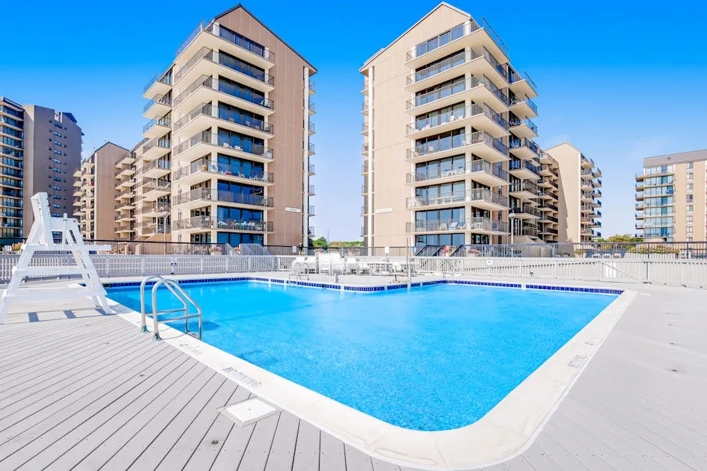 Una piscina al aire libre está frente a varios edificios de apartamentos.