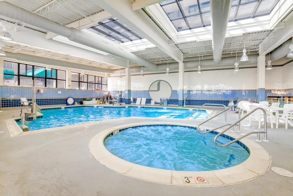 Una piscina cubierta con un spa circular con burbujas en primer plano.