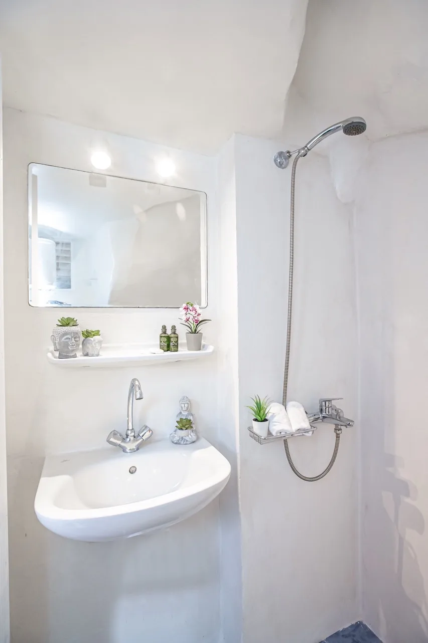 A bathroom with a wall-mounted sink and shower.