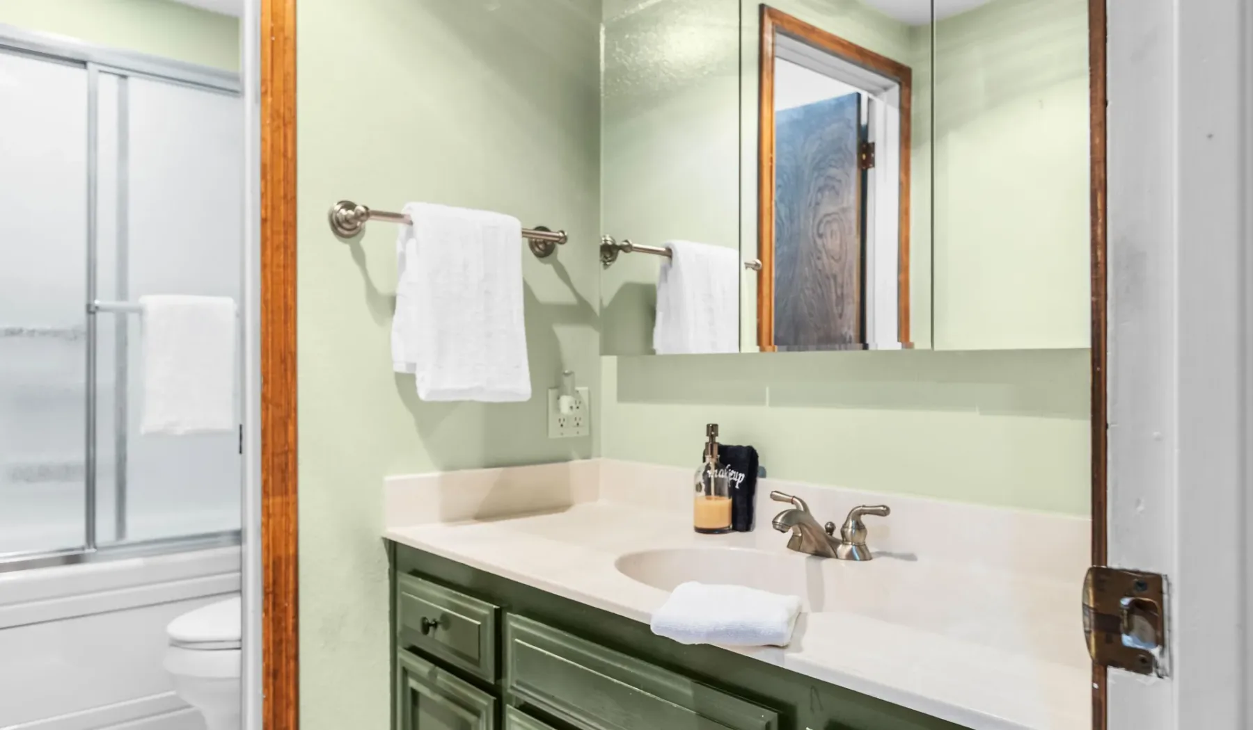 A bathroom vanity with a sink and a large wall mirror.