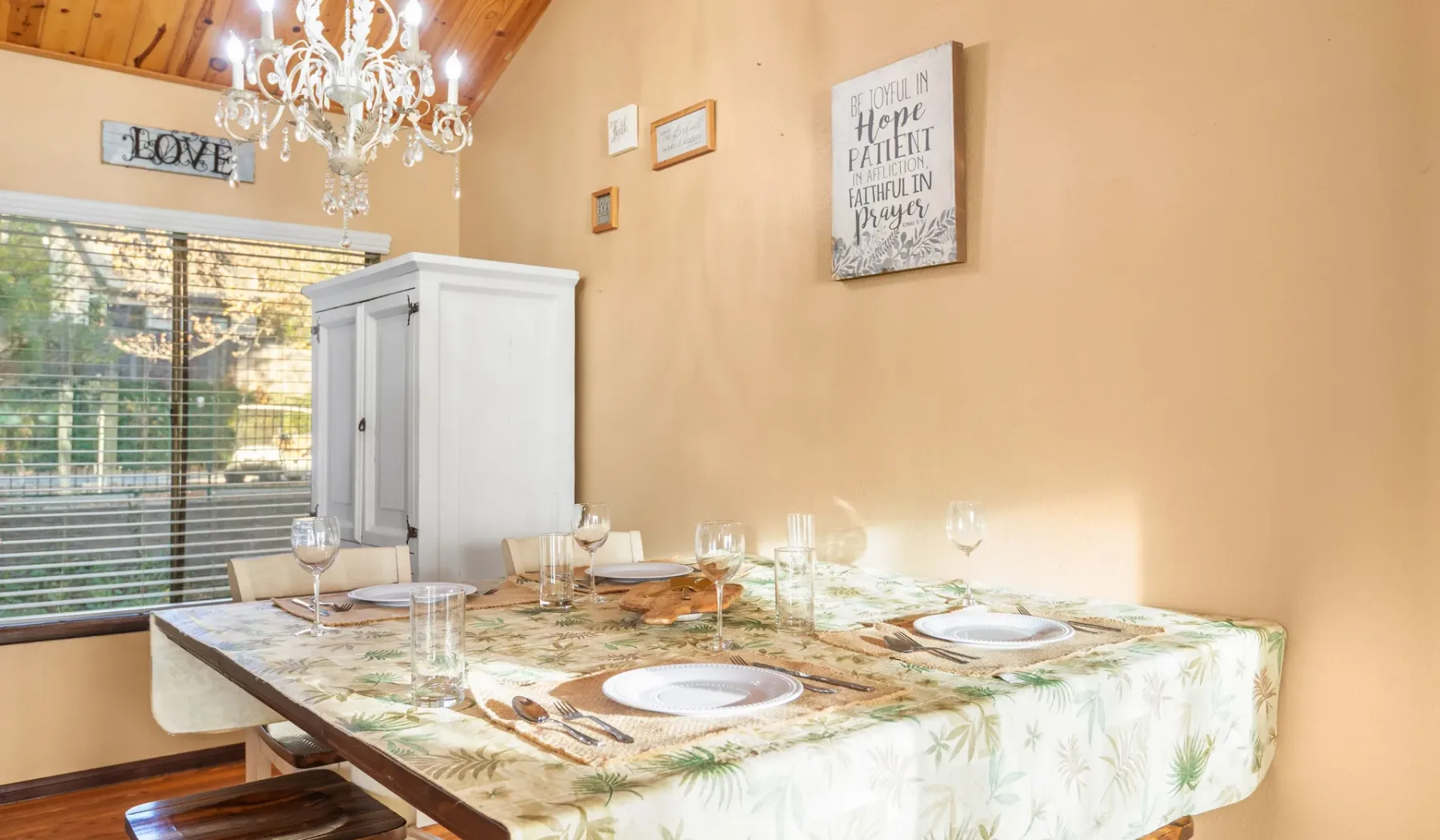 A dining area with a set table beside a large window.